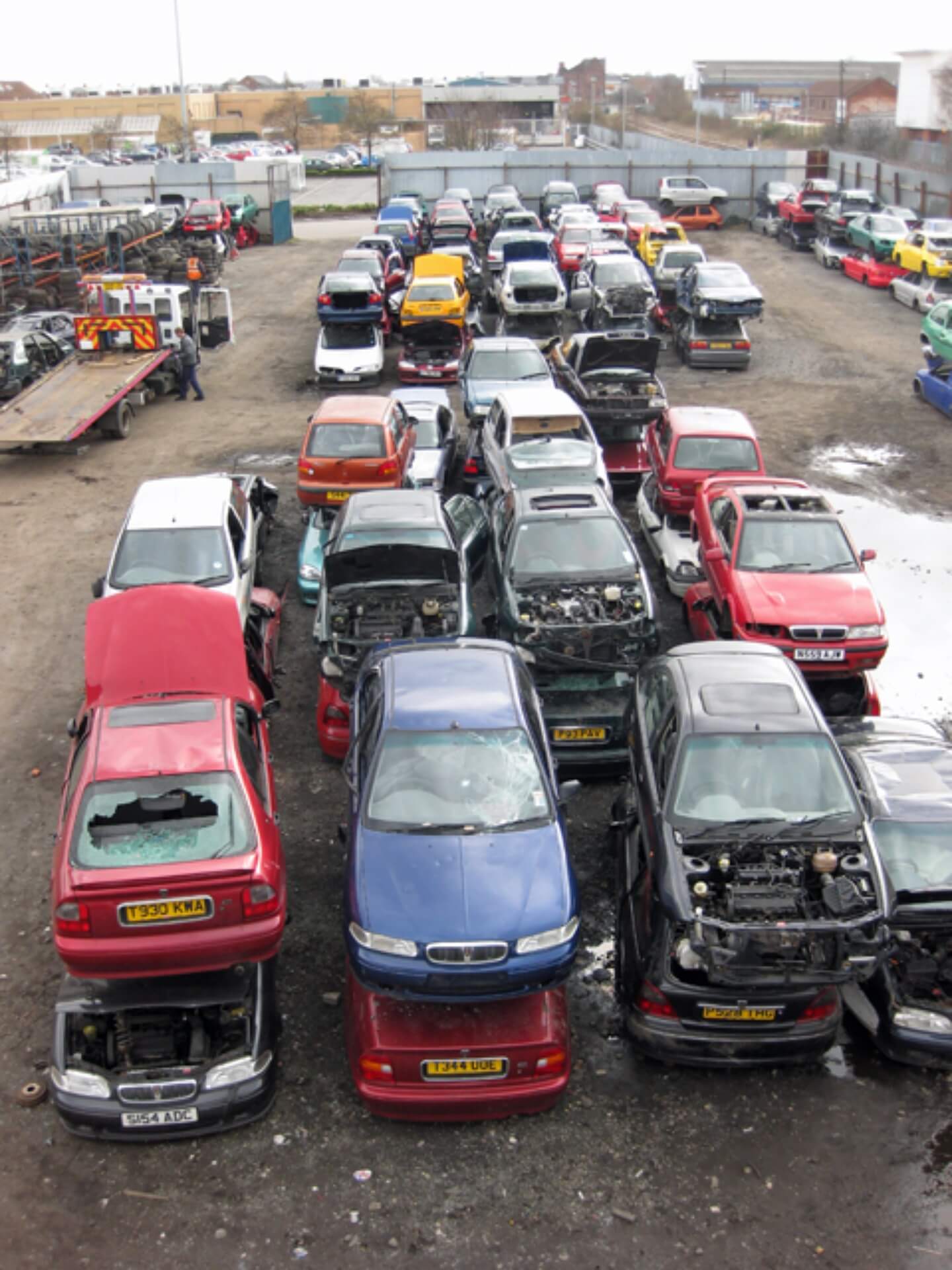 A large car salvage yard with cars stacked